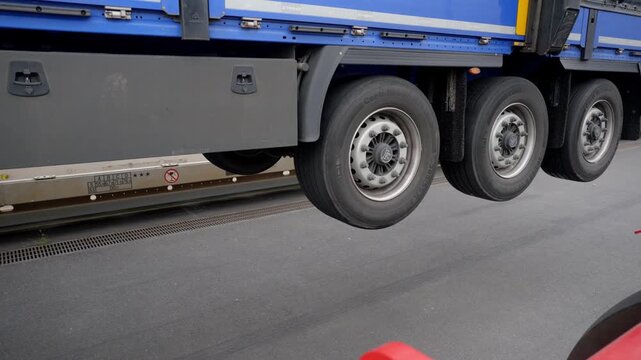 Close-up of semi-trailer axles transferring off rail flatcar onto port terminal ground at Le Havre.