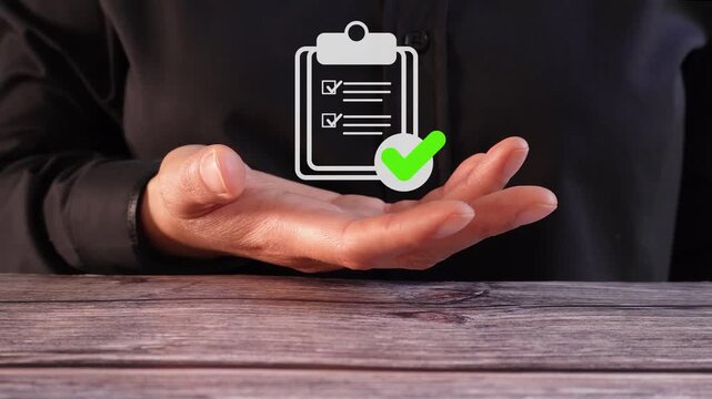 Hand gestures over wooden table. Clipped checklist appears above palm. Green checkmark signals approval. Professional, confident, decisive posture. Ideal for business, compliance, or planning themes