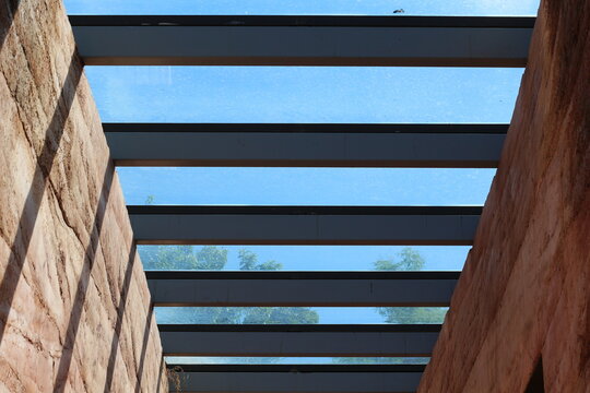 Modern architecture with rammed earth walls and a glass roof overlooking trees