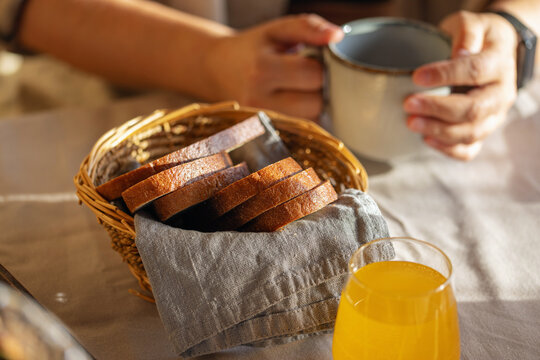 A wicker basket of rye bread on a wooden table. Slow breakfast concept