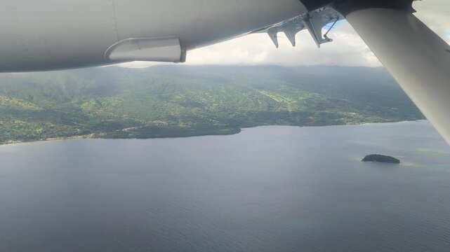 Flying over Pacific ocean along the coastline of tropical Taveuni Island in Fiji, South Pacific, in a small propeller aircraft plane