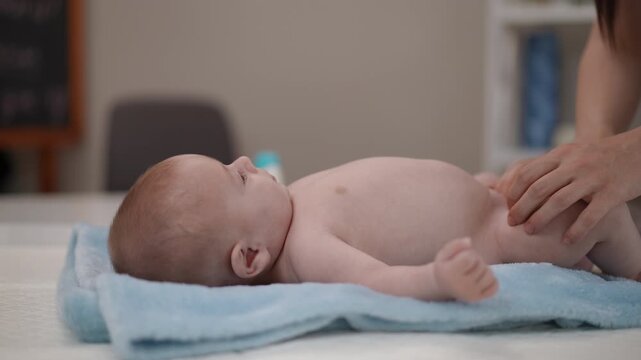 Mother giving a relaxing leg massage to her newborn baby