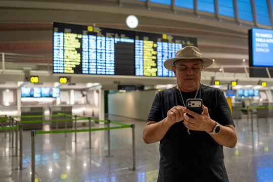 Tourist in airport terminal checking flight information on smartphone