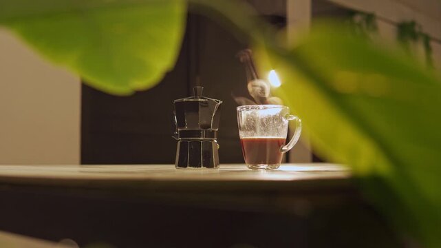 Steaming hot coffee next to italian moka pot