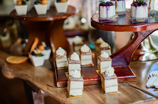 Selecci&oacute;n de mini postres gourmet sobre mesa dulce en elegante celebraci&oacute;n de boda o evento