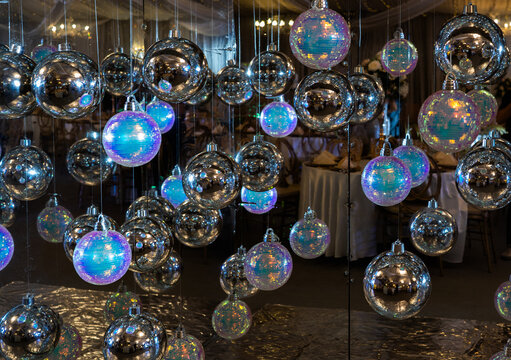 Esferas decorativas plateadas e iridiscentes suspendidas en decoraci&oacute;n elegante para eventos y celebraciones