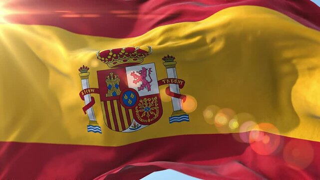 Spanish national flag waving in the wind with sun lens flare