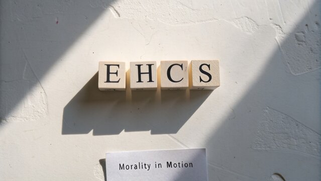 Blocks Spelling EHCS and a Note on Morality in Motion on a White Background with Shadows and Natural Light Effects