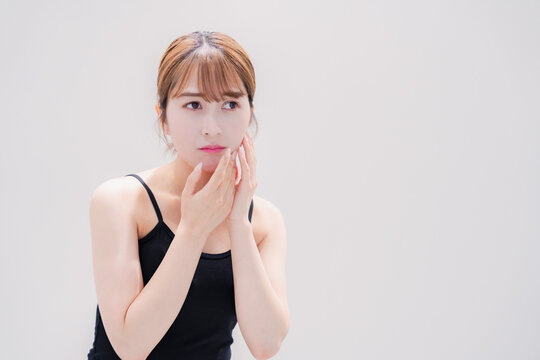お肌の不調に悩む明るい髪色の若い女性
