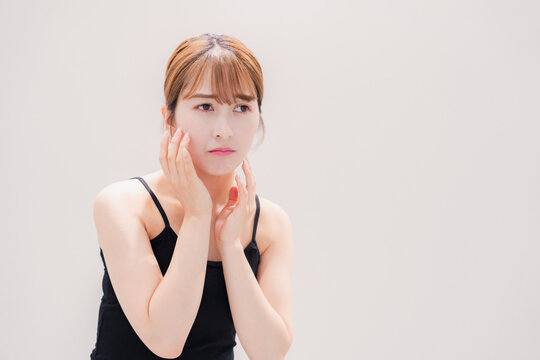 お肌の不調に悩む明るい髪色の若い女性