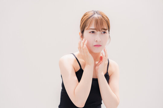 お肌の不調に悩む明るい髪色の若い女性