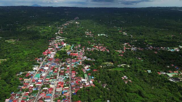 Wide establishing aerial shot of the residential area along Rizal Mabini Burgos Road in Alfonso Cavite Philippines showcasing provincial houses, roadside greenery, and a peaceful daytime neighborhood