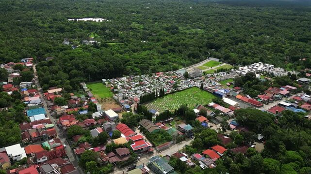 Wide aerial documentary shot of Alfonso Public Cemetery in Cavite Philippines featuring the memorial site, surrounding roads, and the local Alfonso town environment.