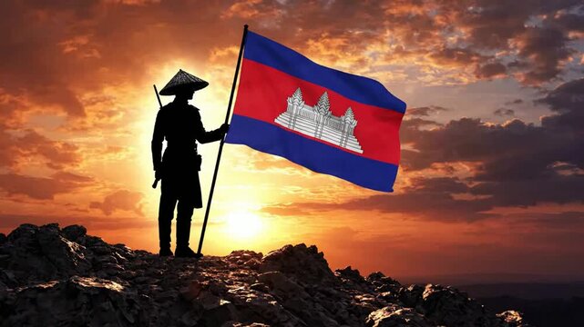 Silhouette of cambodian soldier holding national flag at sunset on mountain peak, patriotic symbolism and national pride concept