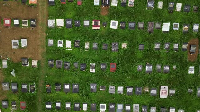 Pullback aerial reveal of Alfonso Public Cemetery in Cavite Philippines showing the relationship between the cemetery grounds and the surrounding community.