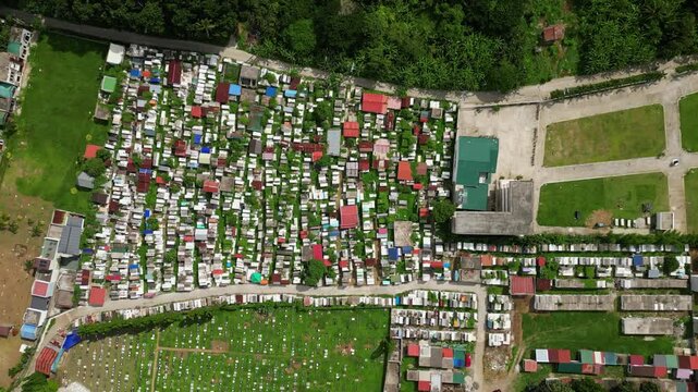 Wide establishing aerial shot of Alfonso Public Cemetery in Alfonso Cavite Philippines showcasing the cemetery grounds, surrounding roads, and nearby provincial landscape during daytime.