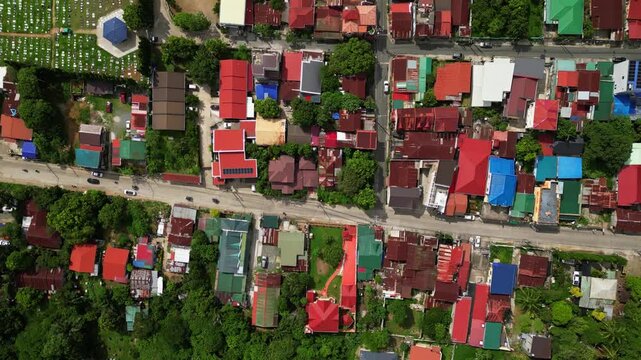 Cinematic tracking aerial shot following the area around CJDC Building in Alfonso Cavite Philippines with visible road access, nearby establishments, and local urban activity.