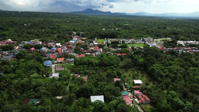 Slow orbit drone footage around a residential area along Alfonso Indang Road in Cavite Philippines featuring homes, roadside vegetation, and the quiet charm of provincial living.