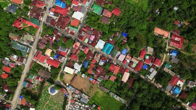 Slow tracking drone shot across the CJDC Building area highlighting roadside buildings, local businesses, and the street layout of Alfonso Cavite town proper.