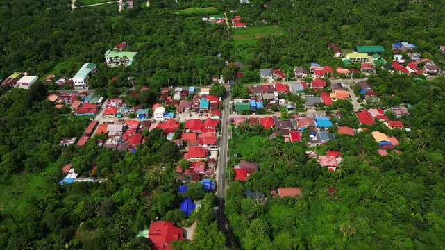 Pullback drone reveal of the neighborhood around Alfonso Indang Road in Alfonso Cavite Philippines showcasing homes, tree cover, and the relaxed atmosphere of province life.
