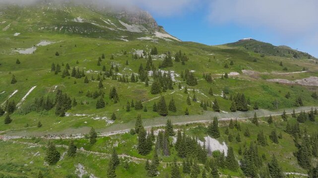 Cinematic aerial drone footage of the French Alps showcasing breathtaking mountain landscapes, dramatic peaks, lush green valleys, dense forests, and pristine alpine nature. Stunning panoramic views c