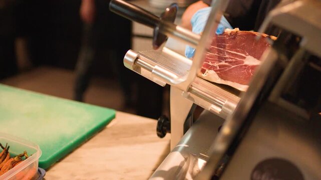 Professional Chef Slicing Cured Ham with Electric Meat Slicer