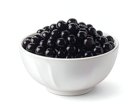 A white ceramic bowl overflowing with shiny black tapioca boba pearls for sweet bubble tea drinks