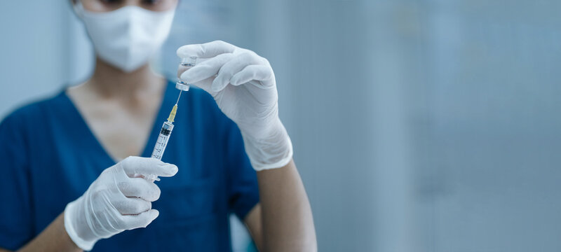 Nurse Preparing Vaccine Injection from Medical Vial Using Sterile Syringe