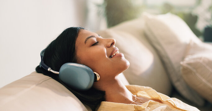 Headphones, happy and woman on sofa in home listening to music, playlist and album on app. Relax, audio tech and person streaming online radio, track or song for break in living room at house.