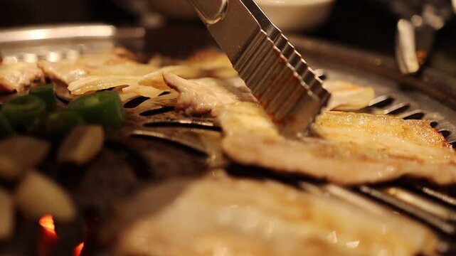 Korean BBQ scene, pork belly grilling on hot grill, smoke rising, fresh vegetables and side dishes