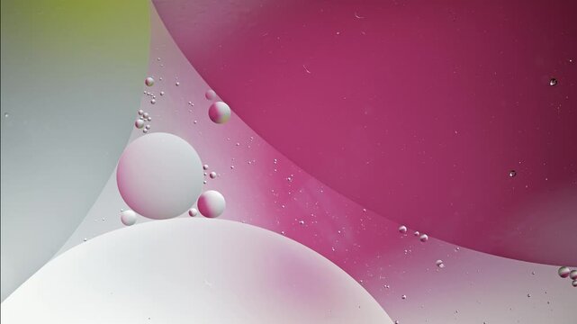 Macro oil droplets suspended in colored liquid with slow drift