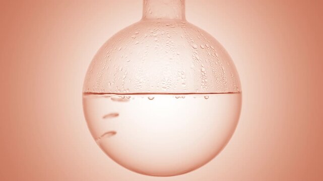 Close-up of bubbles forming and floating upward through pristine transparent liquid gently boiling in a round-bottom flask condensing on it's walls on smooth beige curved backdrop