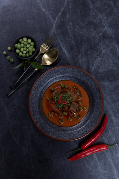 Thai cuisine, homemade beef curry Panang on black background.