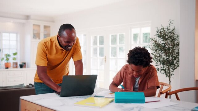 Education, remote work and son high five with father in home for business or learning. Computer, study and success with African family at apartment counter for freelance job or school achievement