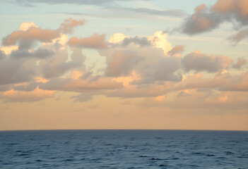 Fototapeta premium Ocean horizon at golden hour with cloudy sky