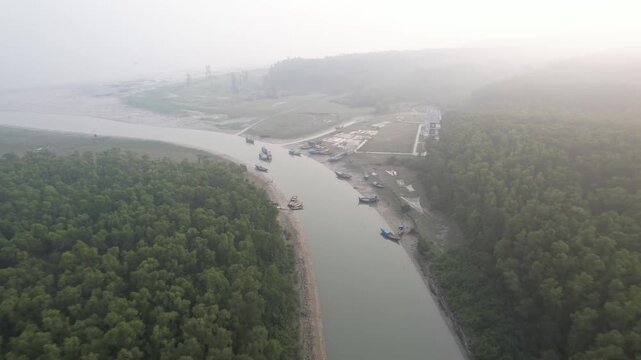 Drone view of boats on a river in a misty coastal forest in Char Kukri Mukri