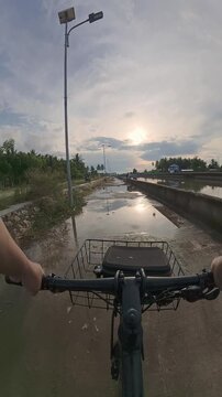POV Riding Bicycle Along Waterway at Sunset