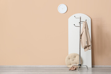 Naklejka premium Minimalist interior with coat rack, beige jacket, and shoes