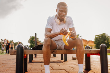 African american athlete peeling banana for healthy snack post workout © Ljustina