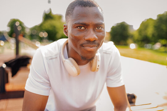African man athlete smiling wearing headphones outdoor