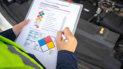A safety engineer is using pen to rating the health risk assessment level of chemical hazardous material in the paperwork form. Industrial safety working scene, close-up and selecitve focus.