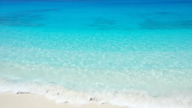 Aerial view of pristine island beach with turquoise water gradients in a calm and sunny atmosphere
