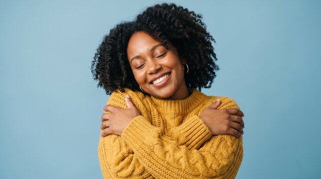 Happy woman with curly hair hugging herself with joy and contentment positivity wellness lifestyle portrait