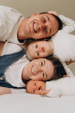 A happy family with two children poses during a home photo session.