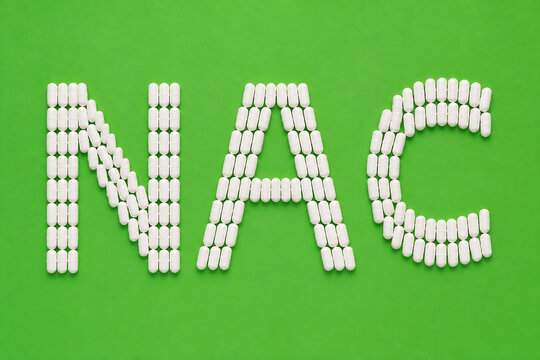White pills are arranged to spell out the letters NAC against a bright green background.
