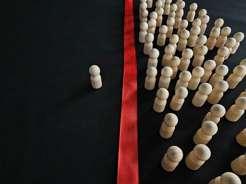 People and one person divided into two groups. A split in society. A division into two camps based on different opinions