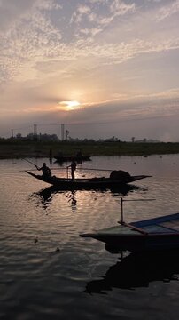 Serene river sunset silhouette traditional wooden boats sailing tranquil water reflections golden