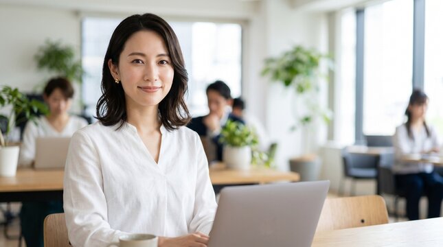オフィスで微笑む清潔感のある日本人女性ビジネスウーマン
