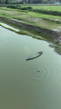 Abandoned canoe drifting towards mysterious vortex in murky water serene landscape with green