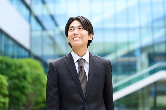 笑顔でオフィス街を歩くビジネスマン